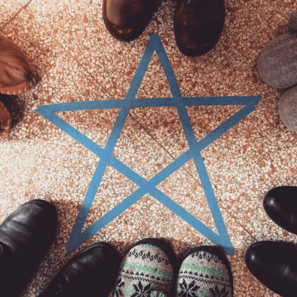 Blue star taped to the floor surrounded by people's feet during private event in Pittsburgh PA